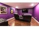 Finished basement media room features plush seating, flat screen TV, hardwood floors, and movie posters at 3902 Eagle Tail Ln, Castle Rock, CO 80104