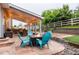 Outdoor patio with custom pavers, gas fire pit, string lighting, outdoor grill, and white picket fence at 3902 Eagle Tail Ln, Castle Rock, CO 80104