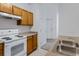 Bright kitchen featuring a white electric range and wood cabinets at 10715 Twenty Mile Rd # 203, Parker, CO 80134