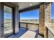 Charming balcony with stone pillar and wood railing showcasing neighborhood views on a sunny day at 8635 Hotchkiss St, Littleton, CO 80125
