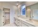 Elegant primary bathroom with dual vanities, a large mirror, and a glass-enclosed shower stall at 8635 Hotchkiss St, Littleton, CO 80125