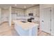 Well-lit kitchen featuring white cabinets, stainless steel appliances, and a central island with a sink at 8635 Hotchkiss St, Littleton, CO 80125