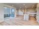 Open-concept living space with wood floors, sliding glass doors, and a view of the kitchen and staircase at 8635 Hotchkiss St, Littleton, CO 80125
