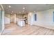 Spacious living room featuring wood floors, bright lighting, and an open layout connecting to the kitchen at 8635 Hotchkiss St, Littleton, CO 80125