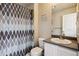 Small bathroom with shower/tub combo, gray vanity, and ample lighting at 9300 E Florida Ave # 1107, Denver, CO 80247