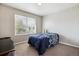 Neutral bedroom with single bed, plush carpet, and large sunny window at 9300 E Florida Ave # 1107, Denver, CO 80247
