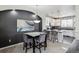 Dining area with a dark accent wall, a marble table, and seating for four adjacent to a bright kitchen at 9300 E Florida Ave # 1107, Denver, CO 80247