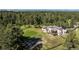 A gorgeous home with a spacious deck surrounded by a lush green lawn, tall trees and a rustic fence at 230 S Big Meadow Trl, Franktown, CO 80116