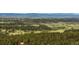 Expansive view of lush green landscapes with scattered trees and distant mountains, offering a serene escape at 230 S Big Meadow Trl, Franktown, CO 80116