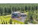 Aerial view of a luxurious home nestled among lush trees, featuring a circular driveway and three car garage at 230 S Big Meadow Trl, Franktown, CO 80116