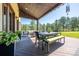 Spacious covered patio featuring an outdoor table, bench seating, and views of the lush surrounding forest at 230 S Big Meadow Trl, Franktown, CO 80116