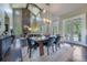 Elegant dining room with a rustic table, modern lighting, and doors leading to the outdoors at 230 S Big Meadow Trl, Franktown, CO 80116