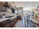 This gourmet kitchen offers a stainless hood vent, custom cabinets, and a sink under the window at 230 S Big Meadow Trl, Franktown, CO 80116