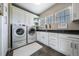 Well-equipped laundry room with sleek white cabinetry and modern appliances at 230 S Big Meadow Trl, Franktown, CO 80116