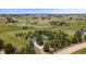 An aerial view shows the home, garages, and spacious lot, dotted with trees at 723 Brussels Dr, Parker, CO 80138