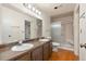 Well-lit bathroom with double sinks, vanity, and glass-enclosed shower at 723 Brussels Dr, Parker, CO 80138
