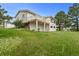 Back of the house with large deck surrounded by grass and trees at 723 Brussels Dr, Parker, CO 80138