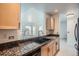 Kitchen with granite counters, wood cabinets, and a view to the living room at 300 W 11Th Ave # 4F, Denver, CO 80204