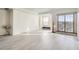 Well-lit living room with gray flooring, a window, and a sliding glass door to a balcony at 300 W 11Th Ave # 4F, Denver, CO 80204