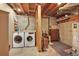 Basement laundry room with modern washer and dryer, open ceiling, and ample storage space, making laundry tasks convenient at 3973 S Joplin Way, Aurora, CO 80013
