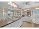 Bright bathroom featuring dual sinks, white cabinetry, large mirrors, and glass-enclosed shower at 14284 W 88Th Dr # B, Arvada, CO 80005