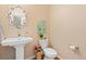 Stylish powder room features a decorative mirror, pedestal sink, and charming wall art at 14284 W 88Th Dr # B, Arvada, CO 80005