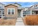 Charming townhome with stone accents, a green front door, and a well-maintained yard at 14284 W 88Th Dr # B, Arvada, CO 80005