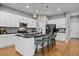 Modern kitchen island with bar seating, white cabinets, black countertops, and stainless appliances at 14284 W 88Th Dr # B, Arvada, CO 80005