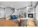 Bright living room features hardwood floors, a fireplace, and a staircase to the upper level at 14284 W 88Th Dr # B, Arvada, CO 80005