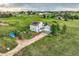 Aerial view of a two-story light blue home with a large yard, solar panels, and mature trees at 8370 Midsummer Ln, Elizabeth, CO 80107
