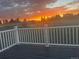 Scenic backyard view from a deck, featuring a beautiful sunset with livestock in the distance at 8370 Midsummer Ln, Elizabeth, CO 80107