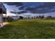 Expansive backyard with lush green grass, fenced areas, and mature trees under a cloudy sky at 8370 Midsummer Ln, Elizabeth, CO 80107