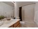Bright bathroom featuring a large mirror, oak vanity, and a shower with a white-tiled surround at 8370 Midsummer Ln, Elizabeth, CO 80107