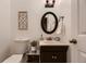 Stylish powder room featuring decorative mirror and sink with dark vanity at 8370 Midsummer Ln, Elizabeth, CO 80107