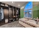 Elegant bathroom featuring a soaking tub with mountain mural and custom closet organizers at 8370 Midsummer Ln, Elizabeth, CO 80107