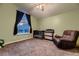 Neutral bedroom with crib, recliner, carpet and scenic view window at 8370 Midsummer Ln, Elizabeth, CO 80107