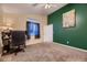 Cozy bedroom with carpet, desk, and dark green accent wall at 8370 Midsummer Ln, Elizabeth, CO 80107