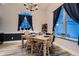 Bright dining room featuring a wooden table set for four, accented with navy curtains and natural light at 8370 Midsummer Ln, Elizabeth, CO 80107