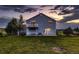 Two-story home featuring a balcony, well-manicured lawn, and inviting outdoor lighting at 8370 Midsummer Ln, Elizabeth, CO 80107