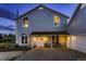 Inviting front porch with dual doors and outdoor seating, illuminated by warm lighting, exudes curb appeal at 8370 Midsummer Ln, Elizabeth, CO 80107