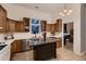 Bright kitchen featuring tile flooring, center island, wood cabinets, and stainless steel dishwasher at 8370 Midsummer Ln, Elizabeth, CO 80107