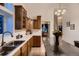 Well-lit kitchen featuring wood cabinets, double sink, and open access to dining area at 8370 Midsummer Ln, Elizabeth, CO 80107