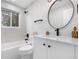 Modern bathroom with a sleek vanity, round mirror, and shower over bathtub at 2320 S Valley Hwy, Denver, CO 80222