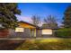 Single-story brick home with a modern front door, large windows, and mature trees at 2320 S Valley Hwy, Denver, CO 80222