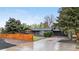 Charming single-story home with a spacious driveway, mature trees, and a privacy fence at 2320 S Valley Hwy, Denver, CO 80222