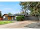 Single-story home with gray brick, modern wood design, and a well-maintained lawn at 2320 S Valley Hwy, Denver, CO 80222
