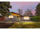 Charming gray brick home featuring a modern teal door, large windows, and a manicured front lawn at 2320 S Valley Hwy, Denver, CO 80222
