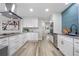 Modern kitchen with white cabinets, gray countertops, stainless steel appliances, and stylish blue backsplash tile at 2320 S Valley Hwy, Denver, CO 80222
