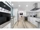 Open concept kitchen featuring stainless appliances, modern finishes, eat-in bar, and adjacent dining space at 2320 S Valley Hwy, Denver, CO 80222