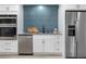 Contemporary kitchen featuring stainless steel appliances, undermount sink, and a bold blue accent tile backsplash at 2320 S Valley Hwy, Denver, CO 80222